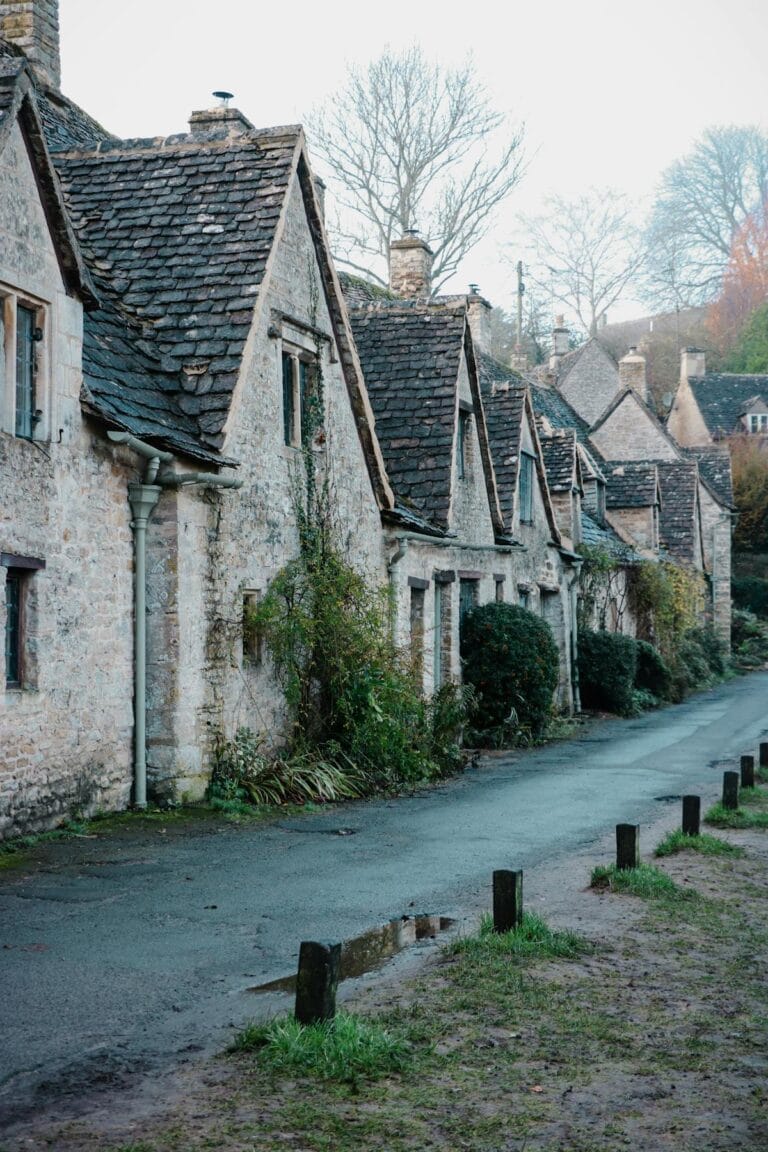 Traditionella honungsfärgade stenhus i Cotswolds by på engelska landsbygden