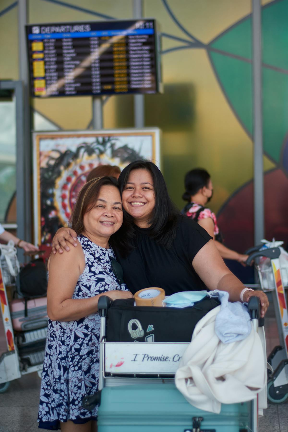 Mor och dotter kramas i flygplatsterminalen