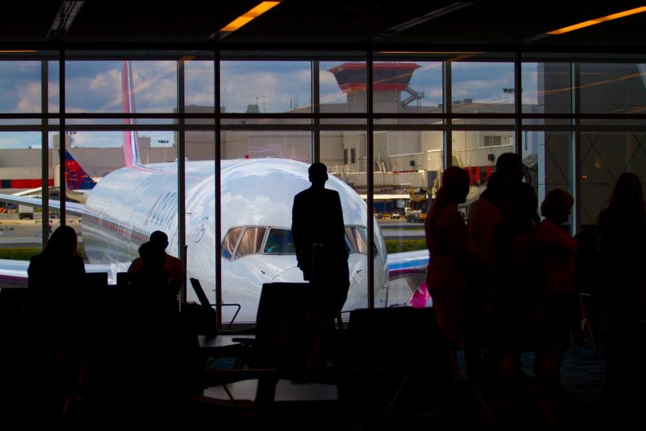 Siluetter av resenärer som väntar vid flygplatsterminal illustrerar familjer som behöver UK ETA 2026