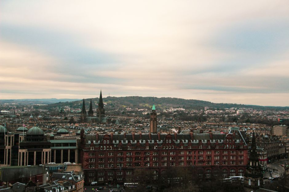 Flygvy över Edinburghs historiska stenarkitektur och tak där boende bokas tidigt under festivalen
