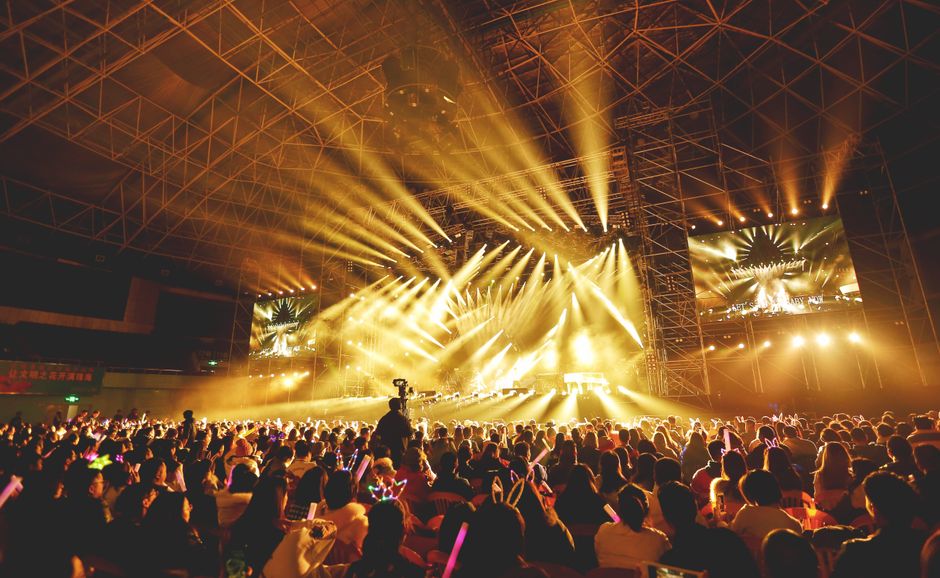 Färgstark ljusshow över en tät konsertpublik och scen under en stadionspelning i Storbritannien