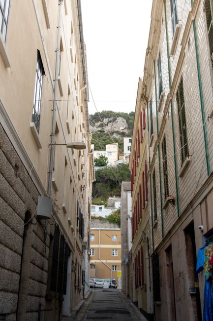 En gata i Gibraltars centrum med butiker och besökare en solig dag vid Medelhavet