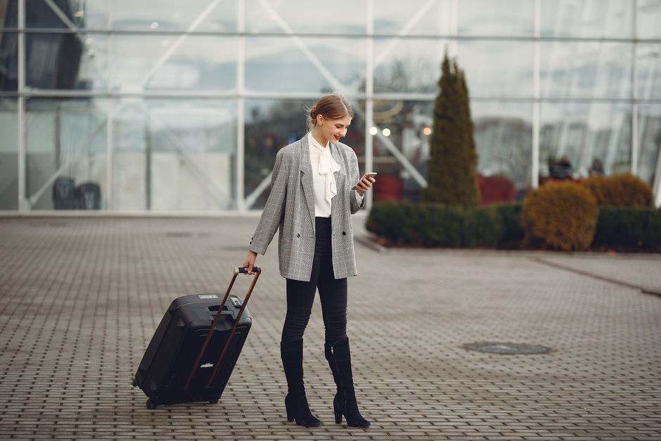 En resenär använder mobilen på flygplatsen för att visa sin giltiga UK ETA