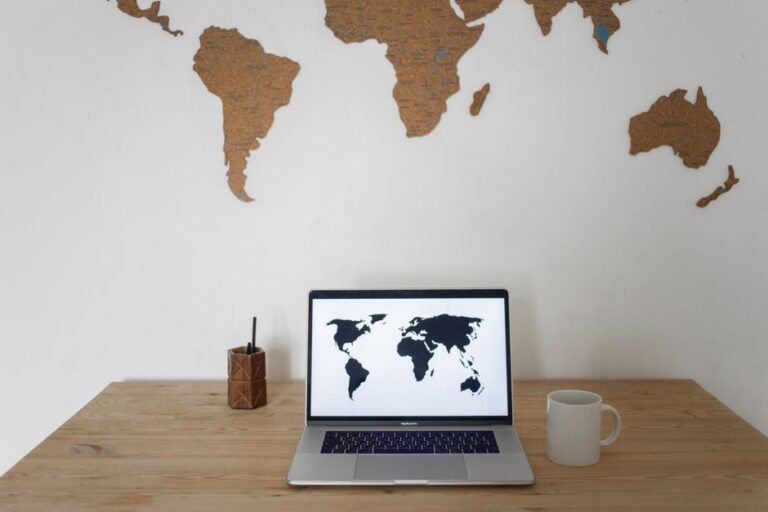 En person planerar en resa till Storbritannien med karta och laptop på skrivbordet